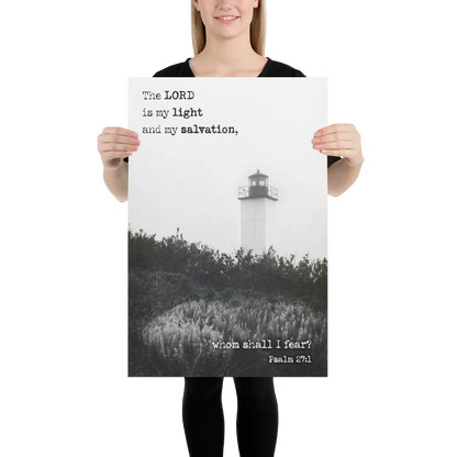 Person holding a poster with a lighthouse and religious text against a white background