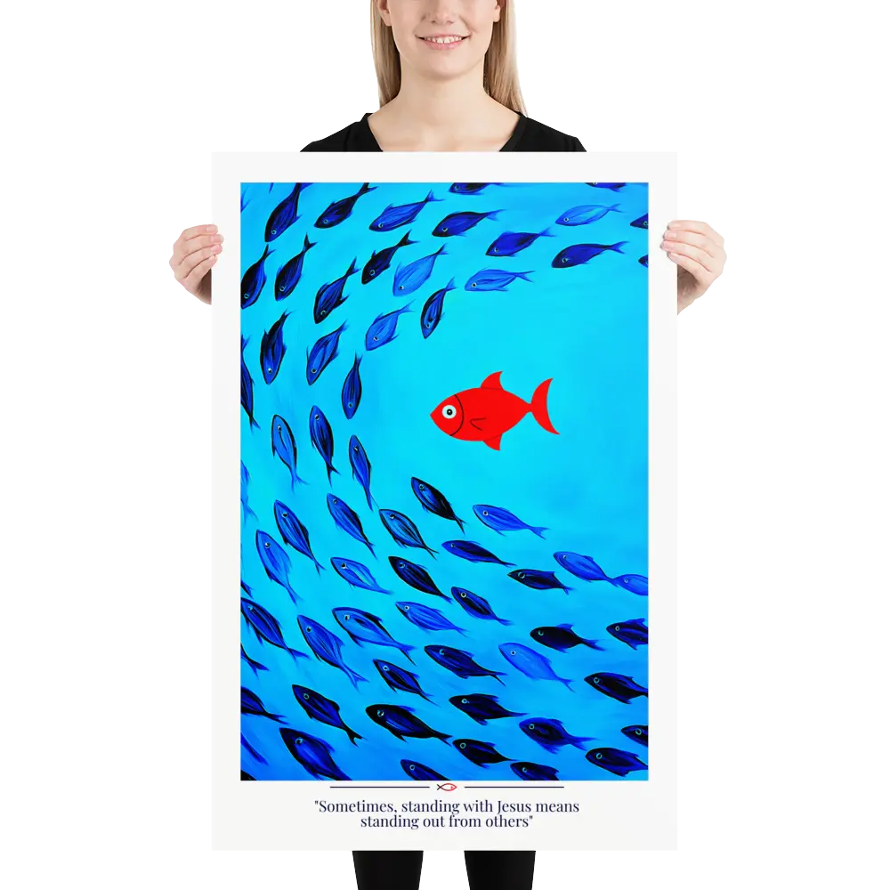 Person holding a poster with a red fish among blue fish and text on a white background