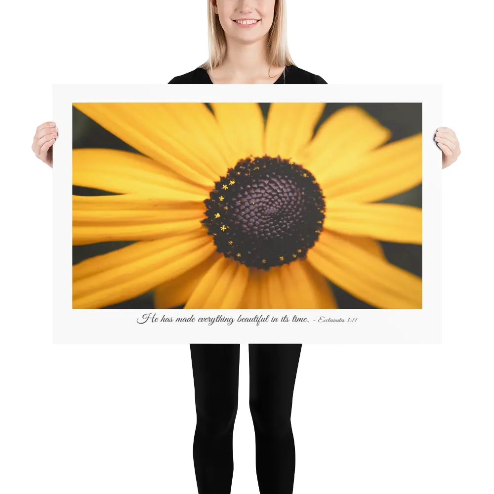 Person holding a large print of a yellow flower with a dark center.