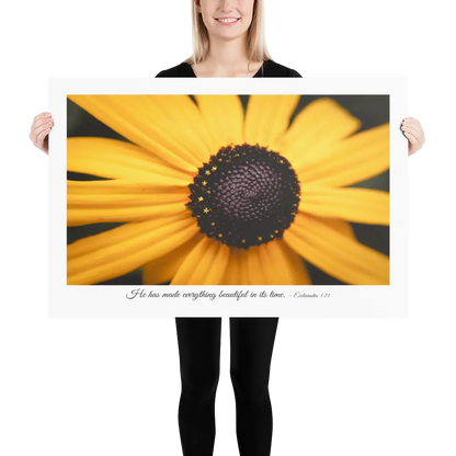 Person holding a large print of a yellow flower with a dark center.