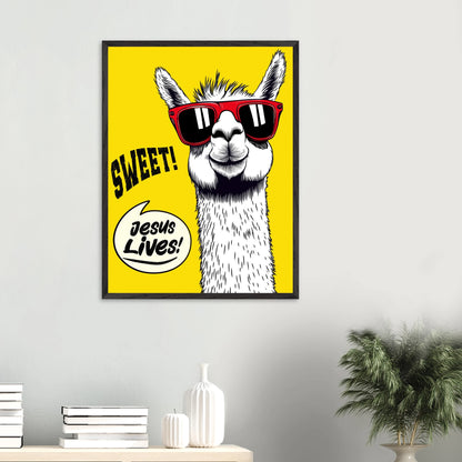 Framed Christian wall art featuring a white llama wearing red sunglasses on a bright yellow background with playful text reading SWEET and Jesus Lives, displayed on a minimalist white wall above a console with books, ceramic vases, and a green plant