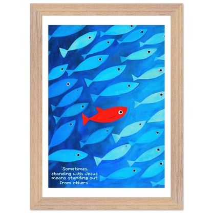 Framed wall art featuring a school of blue fish with a single red fish, and text that reads: 'Sometimes standing with Jesus means standing out from others.'.