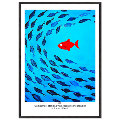 Framed Christian wall art featuring a red fish swimming in water with blue fish, and the text 'Sometimes standing with Jesus means standing out from others' as a quote.