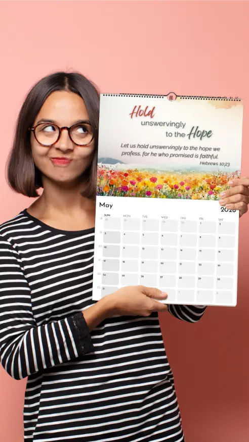 Woman holding a calendar with a floral design and text on a pink background