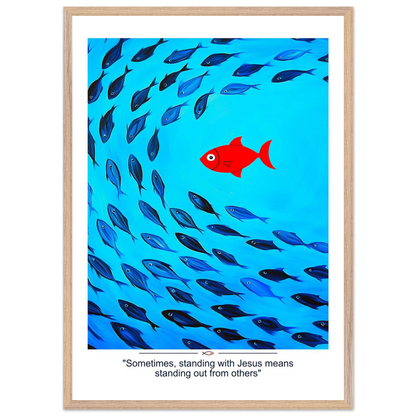 Framed Christian wall art featuring a red fish swimming in water with blue fish, and the text 'Sometimes standing with Jesus means standing out from others' as a quote.