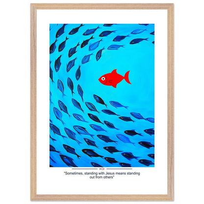 Framed Christian wall art featuring a red fish swimming in water with blue fish, and the text 'Sometimes standing with Jesus means standing out from others' as a quote.